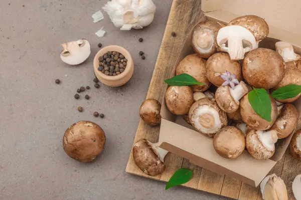 Baharatlı ve otlu taze taze taze kremini mantarlar. Vejetaryen yemeği pişirmek için sağlıklı malzeme. Çiftlikten masaya konsept, düz yatak, sıcak kahverengi arka plan, üst görünüm