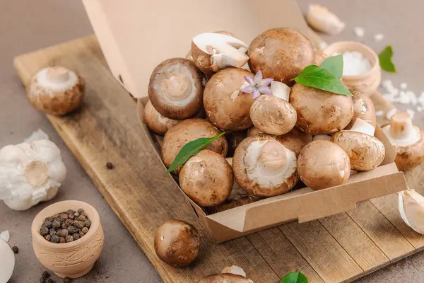 Baharatlı ve otlu taze taze taze kremini mantarlar. Vejetaryen yemeği pişirmek için sağlıklı malzeme. Çiftlikten masaya konsept, düz yatak, sıcak kahverengi arka plan, yakın çekim