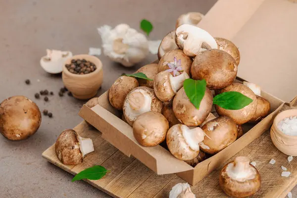 Baharatlı ve otlu taze taze taze kremini mantarlar. Vejetaryen yemeği pişirmek için sağlıklı malzeme. Çiftlikten masaya konsept, düz yatak, sıcak kahverengi arka plan, yakın çekim