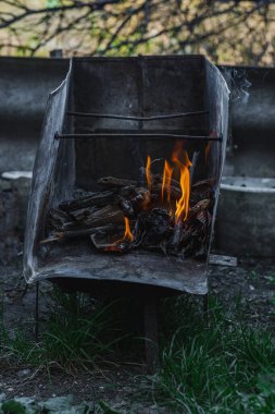 Kötü yaşam koşullarında ısıtmak ya da pişirmek için kullanılan metal bir kapta ateş açın. Kentsel yoksulluğu, yer değiştirmeyi ve kriz ortamlarında hayatta kalmayı yansıtıyor