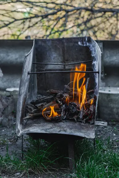 Kötü yaşam koşullarında ısıtmak ya da pişirmek için kullanılan metal bir kapta ateş açın. Kentsel yoksulluğu, yer değiştirmeyi ve kriz ortamlarında hayatta kalmayı yansıtıyor