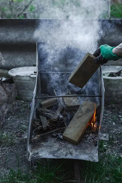 Kötü yaşam koşullarında ısıtmak ya da pişirmek için kullanılan metal bir kapta ateş açın. Kentsel yoksulluğu, yer değiştirmeyi ve kriz ortamlarında hayatta kalmayı yansıtıyor