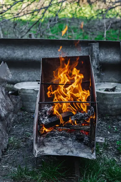 Kötü yaşam koşullarında ısıtmak ya da pişirmek için kullanılan metal bir kapta ateş açın. Kentsel yoksulluğu, yer değiştirmeyi ve kriz ortamlarında hayatta kalmayı yansıtıyor