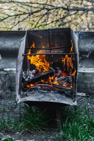 Kötü yaşam koşullarında ısıtmak ya da pişirmek için kullanılan metal bir kapta ateş açın. Kentsel yoksulluğu, yer değiştirmeyi ve kriz ortamlarında hayatta kalmayı yansıtıyor