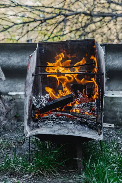 Kötü yaşam koşullarında ısıtmak ya da pişirmek için kullanılan metal bir kapta ateş açın. Kentsel yoksulluğu, yer değiştirmeyi ve kriz ortamlarında hayatta kalmayı yansıtıyor