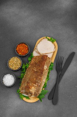 Lezzetli baharatlarla servis edilen yüksek proteinli domuz filetosu. Yemek fotoğrafçılığı için tasarlanmış. Keto ve paleo diyetleri için uygun, siyah taş arka plan, üst görünüm