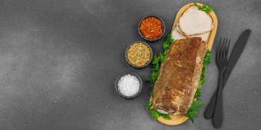 Lezzetli baharatlarla servis edilen yüksek proteinli domuz filetosu. Yemek fotoğrafçılığı için tasarlanmış. Keto ve paleo diyetleri için uygun, siyah taş arkaplan, pankart biçimi