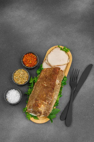 Lezzetli baharatlarla servis edilen yüksek proteinli domuz filetosu. Yemek fotoğrafçılığı için tasarlanmış. Keto ve paleo diyetleri için uygun, siyah taş arka plan, üst görünüm