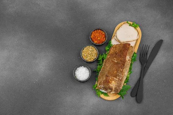 Lezzetli baharatlarla servis edilen yüksek proteinli domuz filetosu. Yemek fotoğrafçılığı için tasarlanmış. Keto ve paleo diyetleri için uygun, siyah taş arka plan, üst görünüm