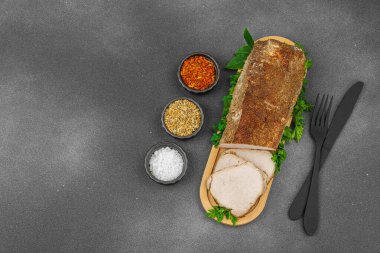 Lezzetli baharatlarla servis edilen yüksek proteinli domuz filetosu. Yemek fotoğrafçılığı için tasarlanmış. Keto ve paleo diyetleri için uygun, siyah taş arka plan, üst görünüm
