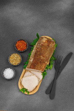 Lezzetli baharatlarla servis edilen yüksek proteinli domuz filetosu. Yemek fotoğrafçılığı için tasarlanmış. Keto ve paleo diyetleri için uygun, siyah taş arka plan, üst görünüm