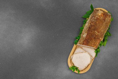 Lezzetli baharatlarla servis edilen yüksek proteinli domuz filetosu. Yemek fotoğrafçılığı için tasarlanmış. Keto ve paleo diyetleri için uygun, siyah taş arka plan, üst görünüm
