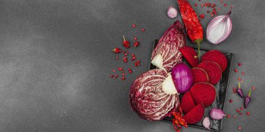 Modern bitki temelli sağlıklı aşçılık tarzı. Düz kırmızı pancar kökü, radicchio, kırmızı biber, kırmızı soğan, arpacık soğanı ve pembe karabiberlerden oluşan düz bir arkaplan, pankart biçimi.