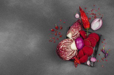 Modern bitki temelli sağlıklı aşçılık tarzı. Düz kırmızı pancar kökü, radicchio, kırmızı biber, kırmızı soğan, soğan soğanı, arpacık soğanı ve pembe karabiber.