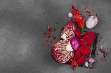 Modern bitki temelli sağlıklı aşçılık tarzı. Düz kırmızı pancar kökü, radicchio, kırmızı biber, kırmızı soğan, soğan soğanı, arpacık soğanı ve pembe karabiber.