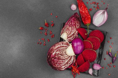 Modern bitki temelli sağlıklı aşçılık tarzı. Düz kırmızı pancar kökü, radicchio, kırmızı biber, kırmızı soğan, soğan soğanı, arpacık soğanı ve pembe karabiber.