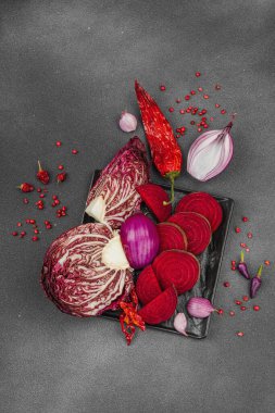 Modern bitki temelli sağlıklı aşçılık tarzı. Düz kırmızı pancar kökü, radicchio, kırmızı biber, kırmızı soğan, soğan soğanı, arpacık soğanı ve pembe karabiber.