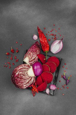 Modern bitki temelli sağlıklı aşçılık tarzı. Düz kırmızı pancar kökü, radicchio, kırmızı biber, kırmızı soğan, soğan soğanı, arpacık soğanı ve pembe karabiber.