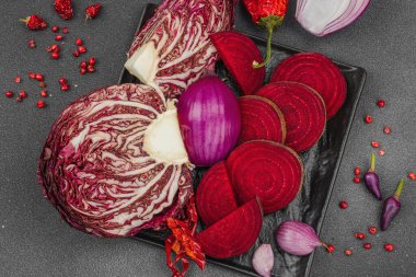 Modern bitki temelli sağlıklı aşçılık tarzı. Düz kırmızı pancar kökü, radicchio, kırmızı biber, kırmızı soğan, soğan soğanı, arpacık soğanı ve pembe karabiber.