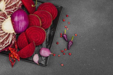 Modern bitki temelli sağlıklı aşçılık tarzı. Düz kırmızı pancar kökü, radicchio, kırmızı biber, kırmızı soğan, soğan soğanı, arpacık soğanı ve pembe karabiber.