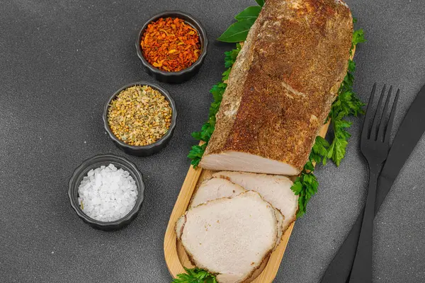 Lezzetli baharatlarla servis edilen yüksek proteinli domuz filetosu. Yemek fotoğrafçılığı için tasarlanmış. Keto ve paleo diyetleri için uygun, siyah taş arka plan, üst görünüm