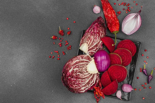 Modern bitki temelli sağlıklı aşçılık tarzı. Düz kırmızı pancar kökü, radicchio, kırmızı biber, kırmızı soğan, soğan soğanı, arpacık soğanı ve pembe karabiber.