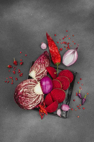 Modern bitki temelli sağlıklı aşçılık tarzı. Düz kırmızı pancar kökü, radicchio, kırmızı biber, kırmızı soğan, soğan soğanı, arpacık soğanı ve pembe karabiber.