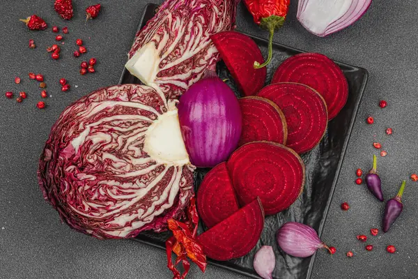 Modern bitki temelli sağlıklı aşçılık tarzı. Düz kırmızı pancar kökü, radicchio, kırmızı biber, kırmızı soğan, soğan soğanı, arpacık soğanı ve pembe karabiber.
