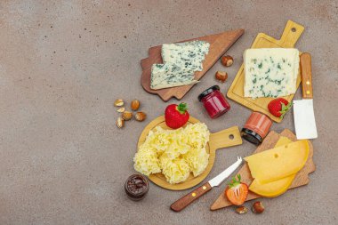 Çilekli, fındıklı ve reçelli peynir çeşitleri. Tahta tahtalarda Tete de Moine, Roquefort, Saint Agur ve Gouda 'yı içerir.