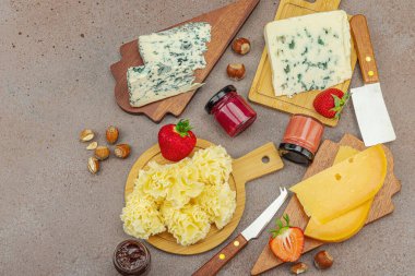 Çilekli, fındıklı ve reçelli peynir çeşitleri. Tahta tahtalarda Tete de Moine, Roquefort, Saint Agur ve Gouda 'yı içerir.