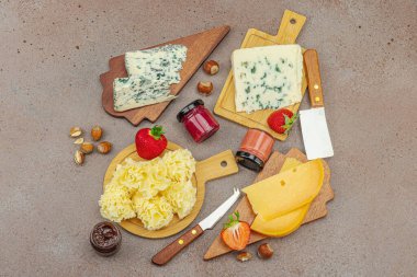 Çilekli, fındıklı ve reçelli peynir çeşitleri. Tahta tahtalarda Tete de Moine, Roquefort, Saint Agur ve Gouda 'yı içerir.