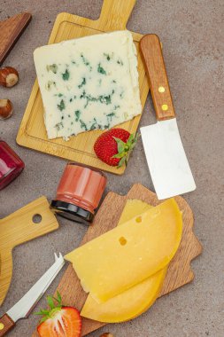 Çilekli, fındıklı ve reçelli peynir çeşitleri. Tahta tahtalarda Tete de Moine, Roquefort, Saint Agur ve Gouda 'yı içerir.