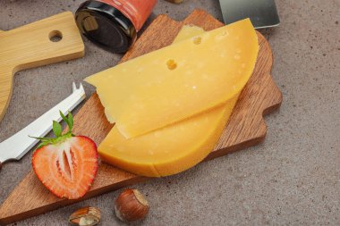 Çilekli, fındıklı ve reçelli peynir çeşitleri. Tahta tahtalarda Tete de Moine, Roquefort, Saint Agur ve Gouda pankartlarını, pankart biçimini içerir