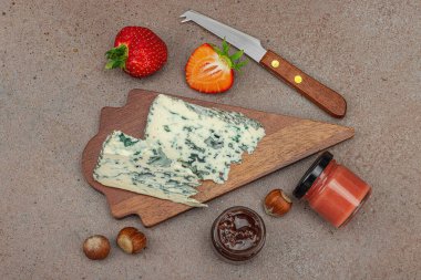 Çilekli, fındıklı ve reçelli peynir çeşitleri. Tahta tahtalarda Tete de Moine, Roquefort, Saint Agur ve Gouda pankartlarını, pankart biçimini içerir