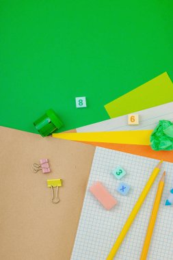 Çevre dostu daire, okul malzemeleri, yeşil arka planda ahşap oyuncaklar. Sıfır atık yaşam tarzı ve bilinçli eğitim teması, okul konseptine geri dönüş, üst görünüm