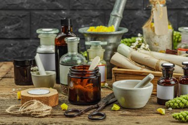 Verbascum çiçekleri, bitkisel kavanozlar, antika aletler ve ahşap masada havan topuyla kırsal eczacılık sahnesi. Alternatif tıp, sağlıklı yaşam tarzı konsepti, kopyalama alanı