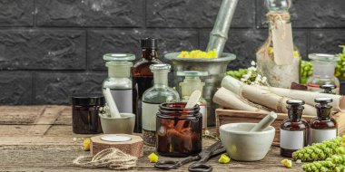 Verbascum çiçekleri, bitkisel kavanozlar, antika aletler ve ahşap masada havan topuyla kırsal eczacılık sahnesi. Alternatif tıp, sağlıklı yaşam tarzı konsepti, afiş biçimi