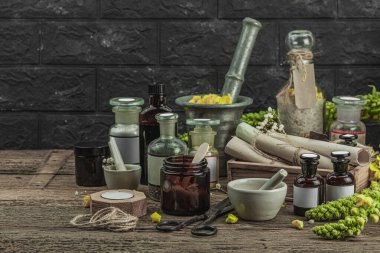 Verbascum çiçekleri, bitkisel kavanozlar, antika aletler ve ahşap masada havan topuyla kırsal eczacılık sahnesi. Alternatif tıp, sağlıklı yaşam tarzı konsepti, kopyalama alanı