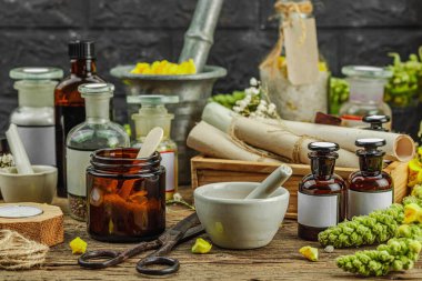 Verbascum çiçekleri, bitkisel kavanozlar, antika aletler ve ahşap masada havan topuyla kırsal eczacılık sahnesi. Alternatif tıp, sağlıklı yaşam tarzı konsepti, kopyalama alanı