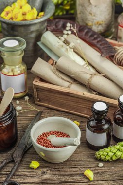 Verbascum çiçekleri, bitkisel kavanozlar, antika aletler ve ahşap masada havan topuyla kırsal eczacılık sahnesi. Alternatif tıp, sağlıklı yaşam tarzı konsepti, kapatın.