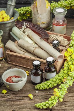 Verbascum çiçekleri, bitkisel kavanozlar, antika aletler ve ahşap masada havan topuyla kırsal eczacılık sahnesi. Alternatif tıp, sağlıklı yaşam tarzı konsepti, kapatın.