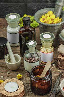 Verbascum çiçekleri, bitkisel kavanozlar, antika aletler ve ahşap masada havan topuyla kırsal eczacılık sahnesi. Alternatif tıp, sağlıklı yaşam tarzı konsepti, kapatın.