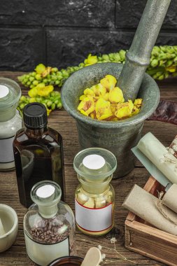 Verbascum çiçekleri, bitkisel kavanozlar, antika aletler ve ahşap masada havan topuyla kırsal eczacılık sahnesi. Alternatif tıp, sağlıklı yaşam tarzı konsepti, kapatın.