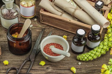 Verbascum çiçekleri, bitkisel kavanozlar, antika aletler ve ahşap masada havan topuyla kırsal eczacılık sahnesi. Alternatif tıp, sağlıklı yaşam tarzı konsepti, afiş biçimi