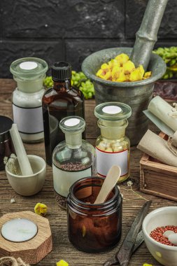 Verbascum çiçekleri, bitkisel kavanozlar, antika aletler ve ahşap masada havan topuyla kırsal eczacılık sahnesi. Alternatif tıp, sağlıklı yaşam tarzı konsepti, kapatın.