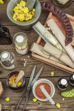 Verbascum çiçekleri, bitkisel kavanozlar, antika aletler ve ahşap masada havan topuyla kırsal eczacılık sahnesi. Alternatif tıp, sağlıklı yaşam tarzı konsepti, üst bakış.