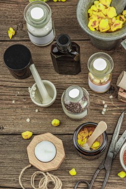 Verbascum çiçekleri, bitkisel kavanozlar, antika aletler ve ahşap masada havan topuyla kırsal eczacılık sahnesi. Alternatif tıp, sağlıklı yaşam tarzı konsepti, üst bakış.