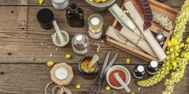 Verbascum çiçekleri, bitkisel kavanozlar, antika aletler ve ahşap masada havan topuyla kırsal eczacılık sahnesi. Alternatif tıp, sağlıklı yaşam tarzı konsepti, afiş biçimi