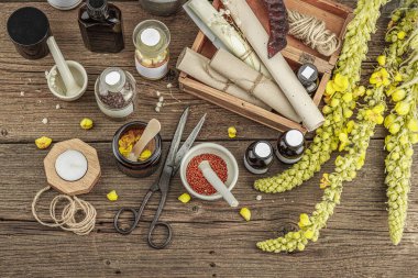 Verbascum çiçekleri, bitkisel kavanozlar, antika aletler ve ahşap masada havan topuyla kırsal eczacılık sahnesi. Alternatif tıp, sağlıklı yaşam tarzı konsepti, üst bakış.