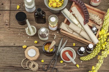 Verbascum çiçekleri, bitkisel kavanozlar, antika aletler ve ahşap masada havan topuyla kırsal eczacılık sahnesi. Alternatif tıp, sağlıklı yaşam tarzı konsepti, üst bakış.